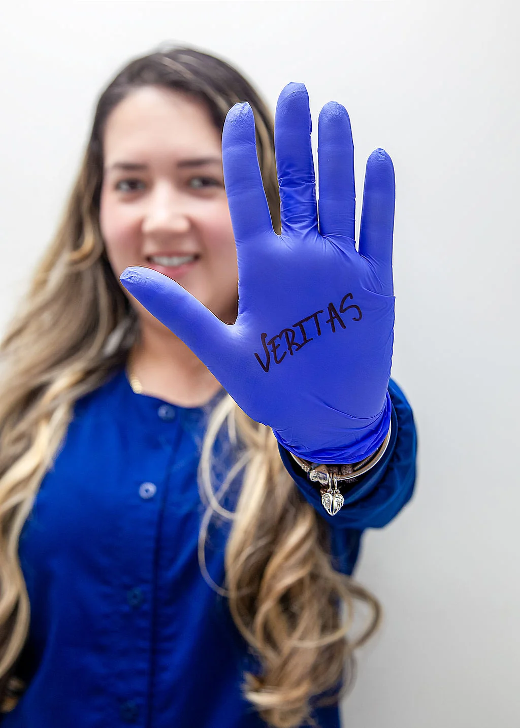 Guante médico con marca Veritas, mostrando orgullo del equipo
